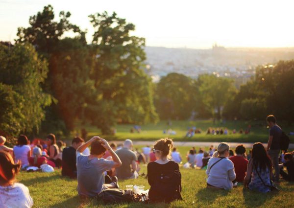 People relaxing and enjoying a sunny day in a bustling city park.